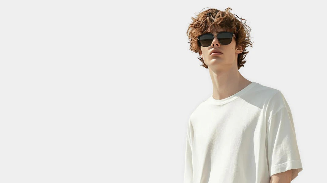 Man wearing sunglasses and a white t-shirt against a light background